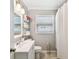 Stylish bathroom featuring a white vanity, matching mirror, and a shower with a curtain at 6914 N Ola Ave, Tampa, FL 33604