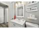 Bright bathroom featuring a white vanity, framed mirror, and decorative shelves for storage at 6914 N Ola Ave, Tampa, FL 33604