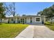 Charming single-story home with well-maintained lawn and landscaping in front at 6914 N Ola Ave, Tampa, FL 33604