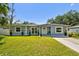 Charming single-story home with well-maintained lawn and landscaping in front at 6914 N Ola Ave, Tampa, FL 33604