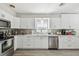 Bright kitchen features white cabinets, stainless steel appliances, and modern countertops at 6914 N Ola Ave, Tampa, FL 33604