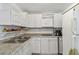 Compact kitchen with white cabinets, granite countertops, and stainless steel sink at 6914 N Ola Ave, Tampa, FL 33604