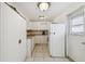 Well-lit kitchen featuring white cabinets, matching appliances, and stylish tile flooring at 6914 N Ola Ave, Tampa, FL 33604