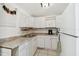 Compact kitchen offering white cabinets, light countertops and an electric range at 6914 N Ola Ave, Tampa, FL 33604