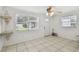 Bright living room with tile flooring, a ceiling fan, and natural light from two windows at 6914 N Ola Ave, Tampa, FL 33604
