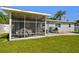 Corner view of a screened-in patio with string lights, and a grill nearby at 6914 N Ola Ave, Tampa, FL 33604