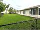 Spacious backyard featuring a green lawn and a black chain link fence at 10627 Mira Vista Dr, Port Richey, FL 34668