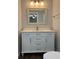 Bathroom features a white vanity, framed mirror, modern lighting fixture, and wood-look tile flooring at 10627 Mira Vista Dr, Port Richey, FL 34668