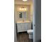 Bathroom features a white vanity, decorative mirror, wood-look tile flooring, and neutral paint at 10627 Mira Vista Dr, Port Richey, FL 34668
