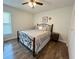 Bedroom featuring a decorative metal bed frame, neutral walls, ceiling fan, and tiled floors at 10627 Mira Vista Dr, Port Richey, FL 34668