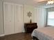 Bedroom showing bed, ceiling fan, wood-look floors, and closet storage at 10627 Mira Vista Dr, Port Richey, FL 34668