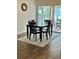 Charming dining area has a wood table, wood floors and is adjacent to the lanai, perfect for seamless indoor/outdoor living at 10627 Mira Vista Dr, Port Richey, FL 34668