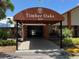 Community building entrance featuring a covered walkway with mature landscaping and vibrant foliage at 10627 Mira Vista Dr, Port Richey, FL 34668