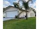 An exterior view shows the home, lawn, and landscaping. A palm tree and other greenery enhance the curb appeal at 10627 Mira Vista Dr, Port Richey, FL 34668