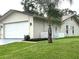 Side view of house with an attached garage and well-kept lawn at 10627 Mira Vista Dr, Port Richey, FL 34668