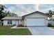 Charming single-story home featuring a two-car garage, well-maintained lawn and simple, yet attractive landscaping at 10627 Mira Vista Dr, Port Richey, FL 34668