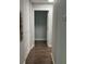 Hallway with wood-look floors leading to an open doorway at 10627 Mira Vista Dr, Port Richey, FL 34668