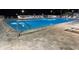 Sparkling community pool with easy access via ladders and a well-maintained stone surround at night at 10627 Mira Vista Dr, Port Richey, FL 34668