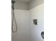 This shower features white tiled walls, shower head, and other fixtures at 10627 Mira Vista Dr, Port Richey, FL 34668