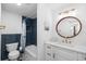 Stylish bathroom featuring blue-tiled shower, modern vanity with round mirror, and gold fixtures at 10716 Donbrese Ave, Tampa, FL 33615