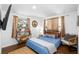 Airy bedroom boasts natural light, hardwood floors, and a calming blue color scheme at 10716 Donbrese Ave, Tampa, FL 33615