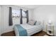 Bright bedroom with hardwood floors, two windows, and simple decor for a cozy feel at 10716 Donbrese Ave, Tampa, FL 33615