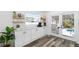 Bright kitchen featuring white cabinets, marble countertops and view to backyard pool at 10716 Donbrese Ave, Tampa, FL 33615