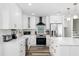 Clean white kitchen with a large island, stainless steel appliances, and tile backsplash at 10716 Donbrese Ave, Tampa, FL 33615
