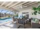 Covered patio with comfortable seating overlooks a refreshing pool and canal view at 10716 Donbrese Ave, Tampa, FL 33615