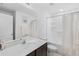 Bright bathroom featuring a white vanity with a quartz countertop and a tub with white shower curtain at 1102 Wynnmere Walk Ave, Ruskin, FL 33570