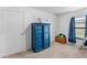 A cozy bedroom featuring a blue dresser with drawers, a nautical lamp, and a toy chest at 1102 Wynnmere Walk Ave, Ruskin, FL 33570