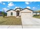 Charming single-story home with a well-manicured lawn and attached two-car garage under a sunny sky at 1102 Wynnmere Walk Ave, Ruskin, FL 33570
