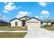 Charming single-story home showcasing a well-manicured lawn and an inviting two-car garage under a sunny sky at 1102 Wynnmere Walk Ave, Ruskin, FL 33570