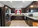 Modern kitchen with stainless steel appliances, dark wood cabinets, granite countertops and tile floors at 1102 Wynnmere Walk Ave, Ruskin, FL 33570