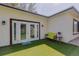 Backyard with artificial turf, patio doors, and charming bench seating for outdoor enjoyment at 1150 7Th Ne Ave, Largo, FL 33770