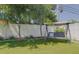 Landscaped backyard with artificial turf, play swing, and patio lounge at 1150 7Th Ne Ave, Largo, FL 33770