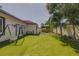 Spacious backyard with lush artificial turf, patio doors, outdoor lounge and white fence at 1150 7Th Ne Ave, Largo, FL 33770