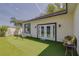 Backyard with artificial turf, patio doors, swing and charming bench seating at 1150 7Th Ne Ave, Largo, FL 33770