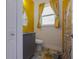 Bright bathroom featuring yellow tile, vanity with gray cabinet, and window with natural light at 1150 7Th Ne Ave, Largo, FL 33770