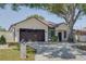 Well-kept home features a large two-car garage and a neatly landscaped front yard with mature tree at 1150 7Th Ne Ave, Largo, FL 33770