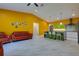 Open-concept kitchen and living room featuring hardwood floors and bright accent wall at 1150 7Th Ne Ave, Largo, FL 33770