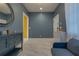 Stylish sitting room with blue-grey walls, white marble floors and view to yellow accented hallway at 1150 7Th Ne Ave, Largo, FL 33770