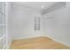 White bedroom featuring hardwood floors, a window with white shutters, crown molding, and a closet at 11644 Meridian Point Dr, Tampa, FL 33626