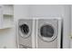 Modern laundry room with side-by-side, front-load washer and dryer units and storage space at 11644 Meridian Point Dr, Tampa, FL 33626