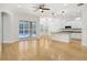 Open-concept living room with hardwood floors, leading to a modern kitchen with stainless appliances and pool view at 11644 Meridian Point Dr, Tampa, FL 33626