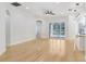 Living room with hardwood floors, white walls, ceiling fan, and sliding glass doors to pool area at 11644 Meridian Point Dr, Tampa, FL 33626