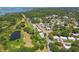 An aerial view of a neighborhood with tree-lined streets and a serene pond at 12020 66Th Ave, Seminole, FL 33772