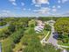 An aerial view of a neighborhood with tree-lined streets and a serene pond at 12020 66Th Ave, Seminole, FL 33772