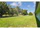 Spacious backyard with lush lawn, surrounded by a metal fence and mature trees at 12020 66Th Ave, Seminole, FL 33772