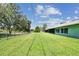 Green backyard with large grassy area, surrounded by a fence and trees, exterior of house with patio at 12020 66Th Ave, Seminole, FL 33772